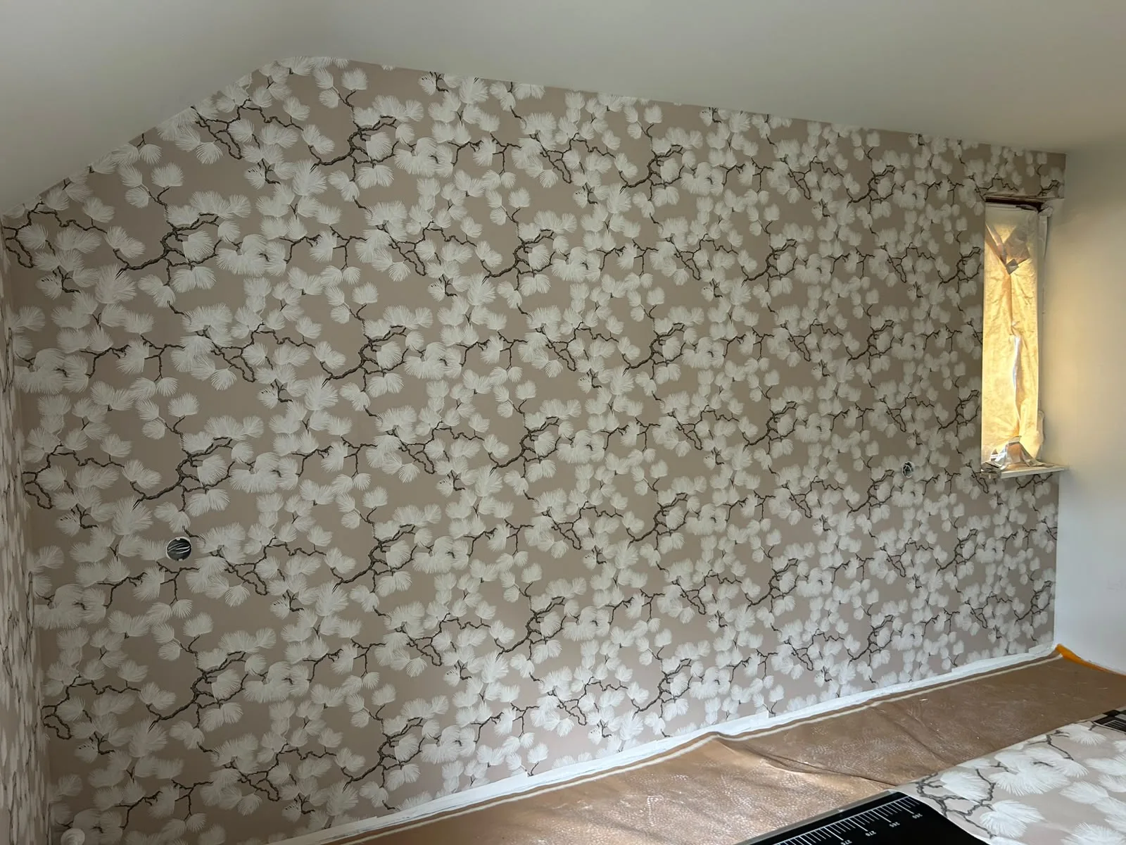 Bloemenbehang in een nis met wandlamp